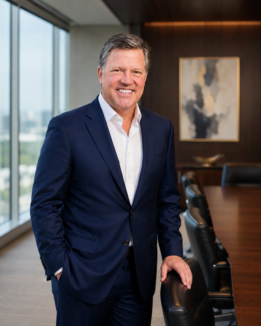 Rick Smith in a navy suit, standing in a boardroom